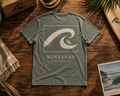 Dune Wash Tee flat lay showing back wave graphic on wooden surface